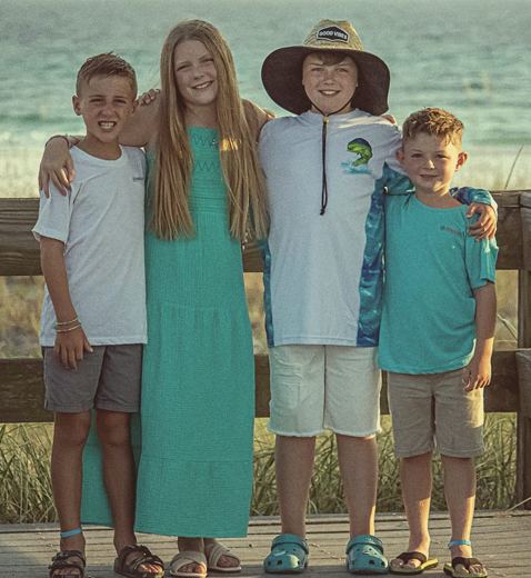 Nayna's four grandchildren on a beach boardwalk