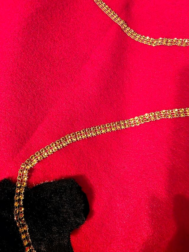 A gold leash stitched across hot pink fabric